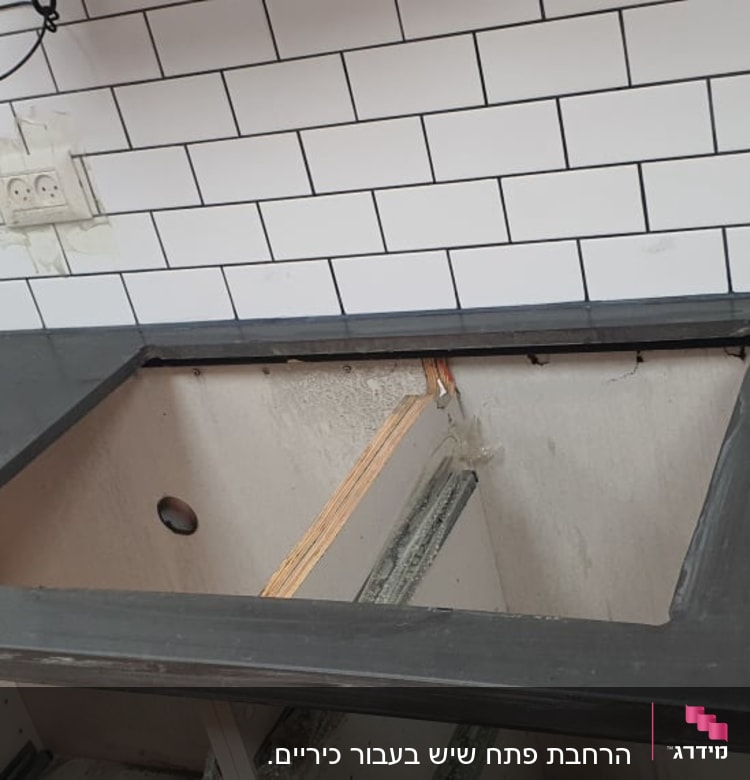 משטח שיש כהה עם חור לכיור במטבח